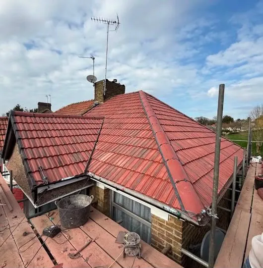 Hipped roof re-tiled in red concrete tiles