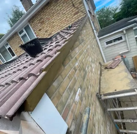 Tiled roof meeting a brick wall during repairs