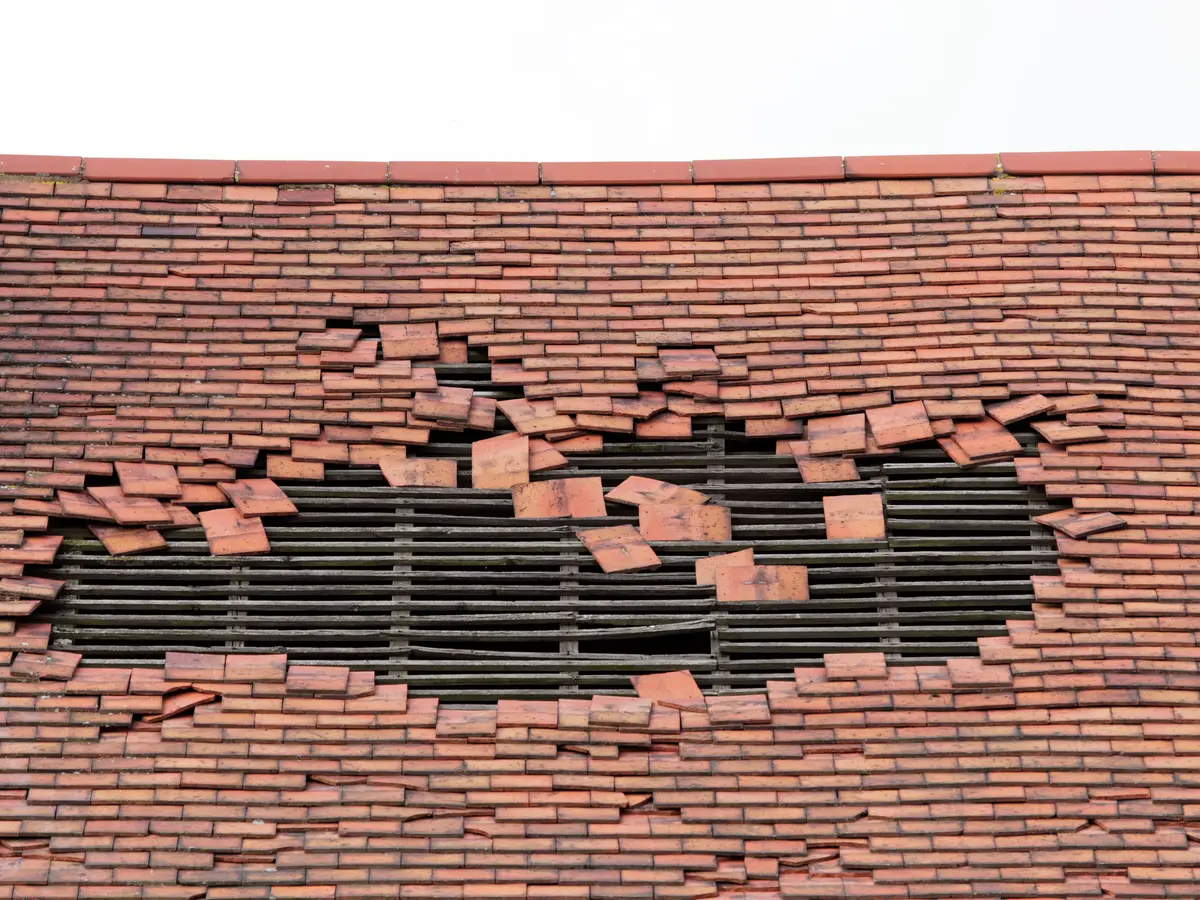 Hole in a tiled roof after storm damage