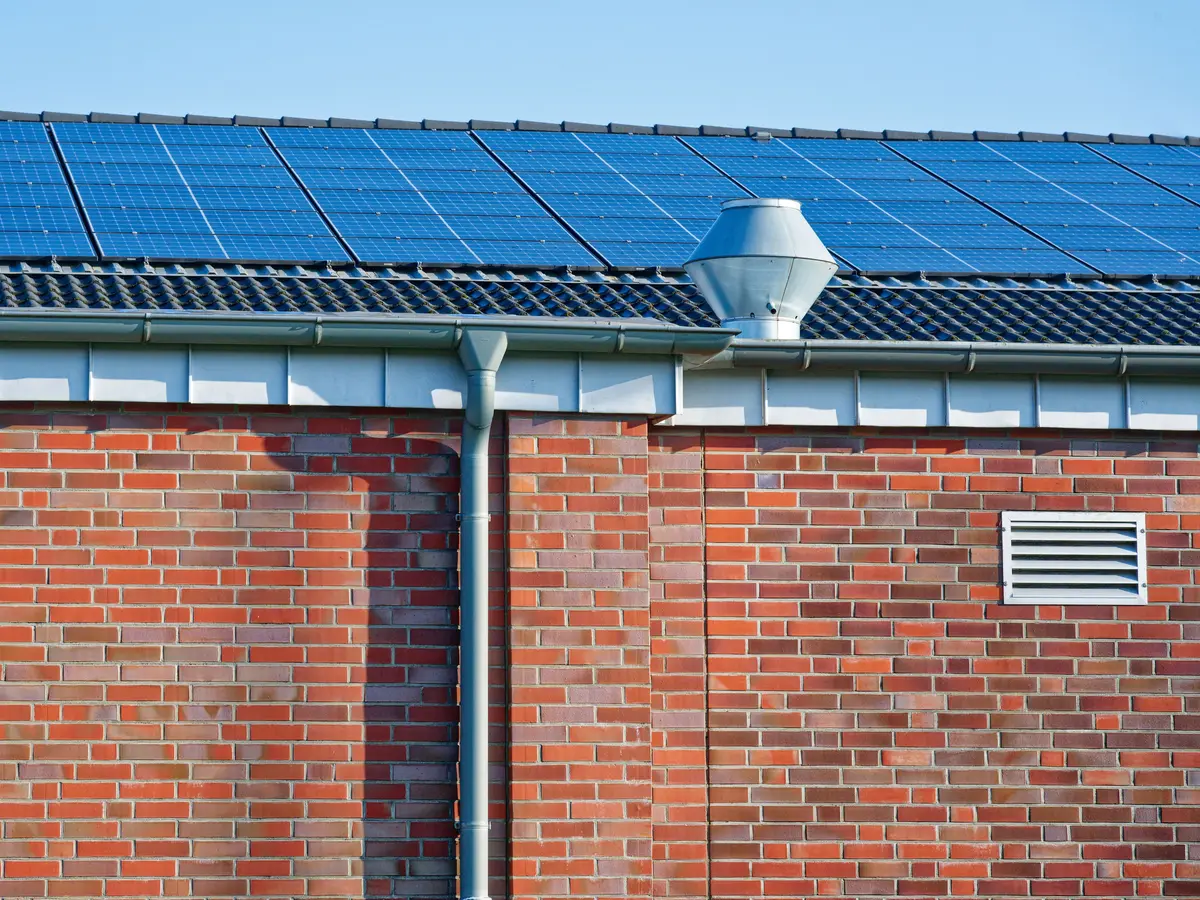 Industrial building roof with metal sheeting and solar panels