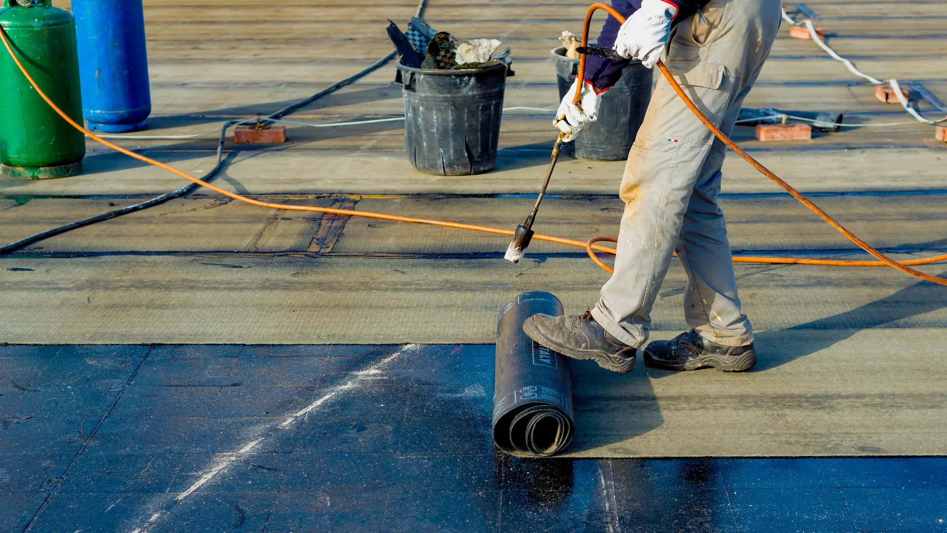 Roofer torching on new felt to a flat roof