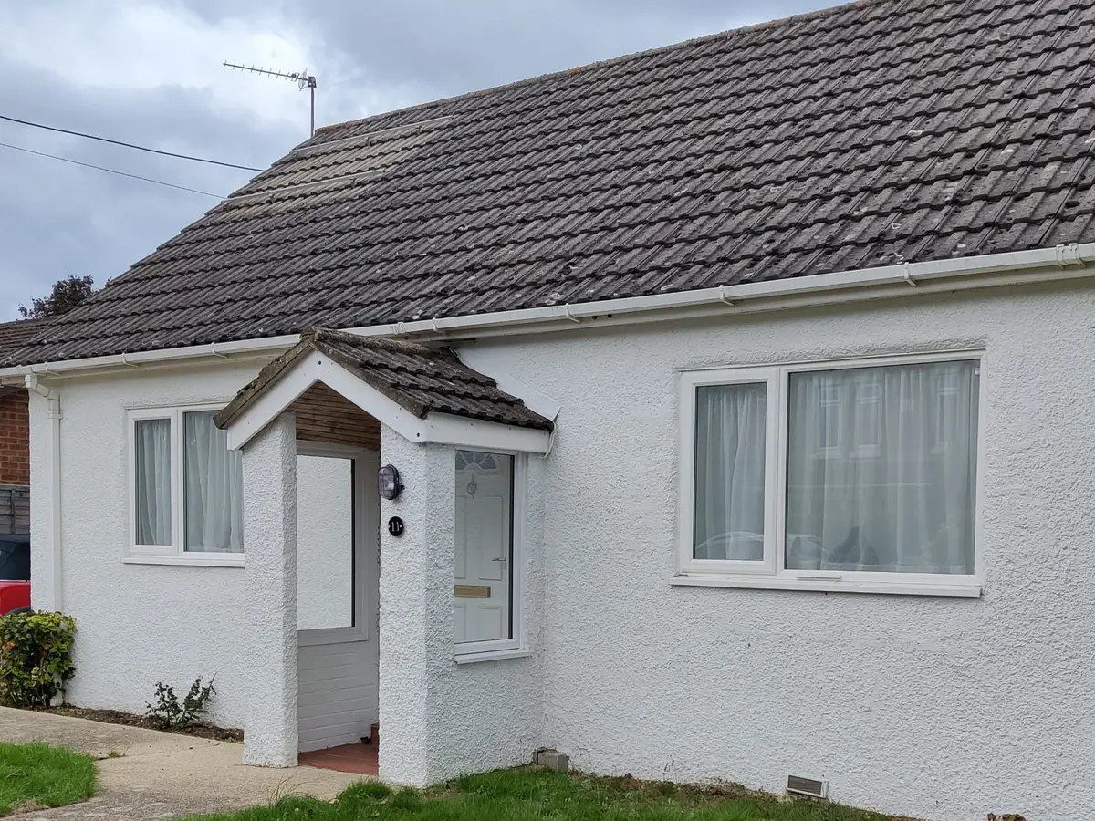Front of a newly rendered white bungalow